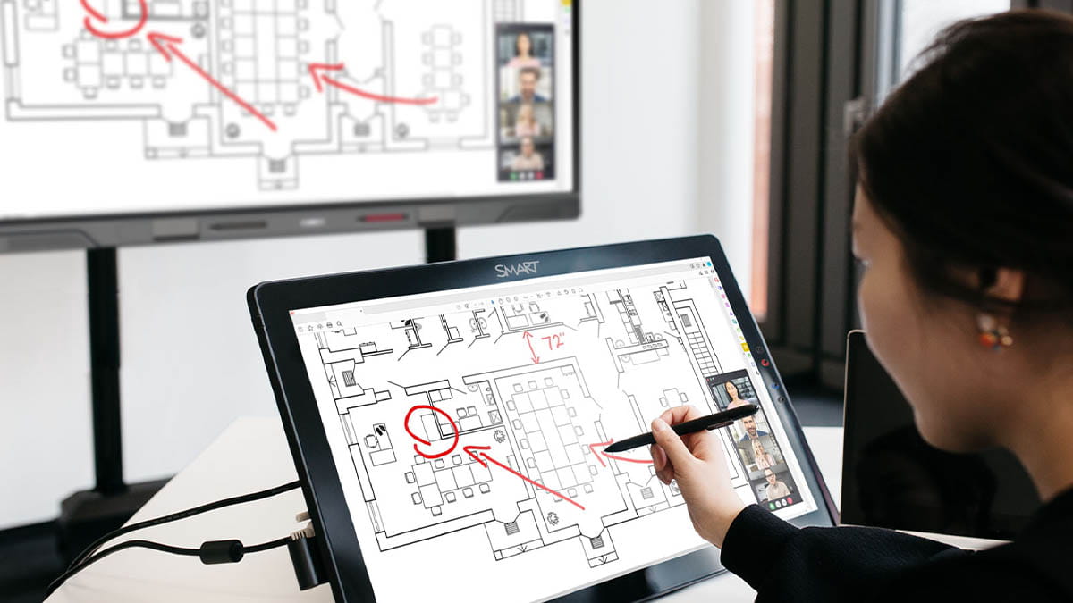 Professional annotating a floor plan during a collaborative session.